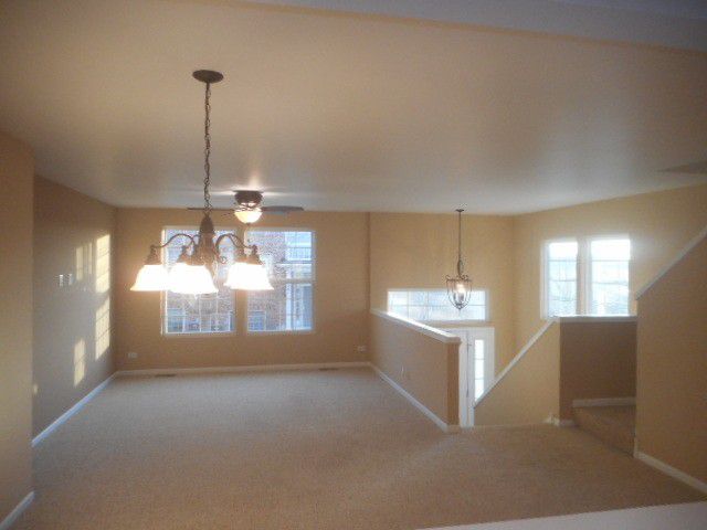 Renovated living space with updating lighting and new carpet