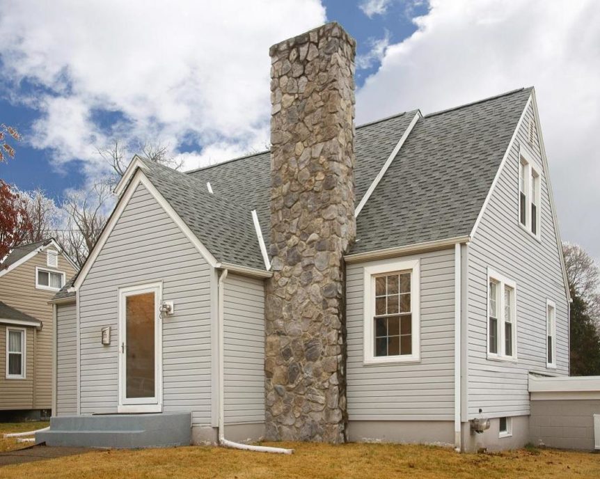 Home with multiple peaks and a stone covered chimney