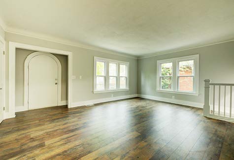 Renovated living space with fresh paint, a couple of windows, and hardwood flooring